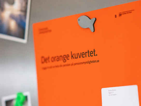 Orange kuvert om pension på kylskåp