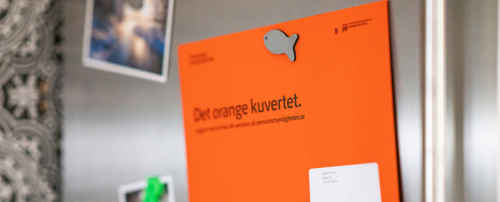 Orange kuvert om pension på kylskåp