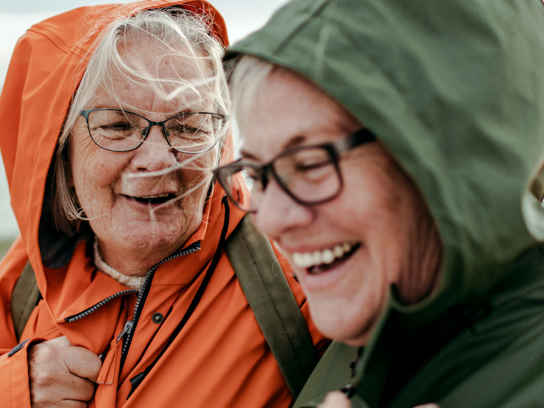 Två äldre kvinnor med glasögon i vindjackor
