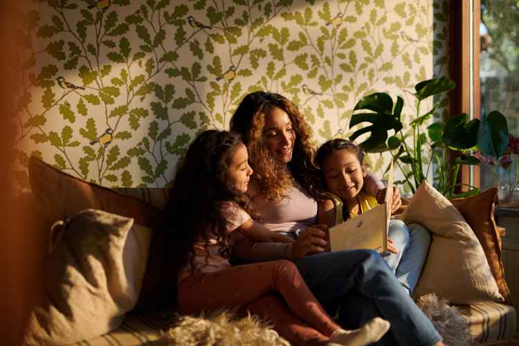 Familj i soffa läser saga